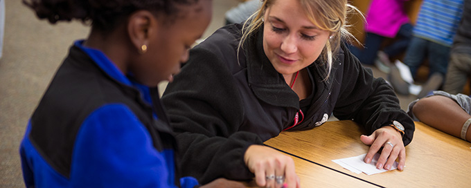 Student working with child in after school program